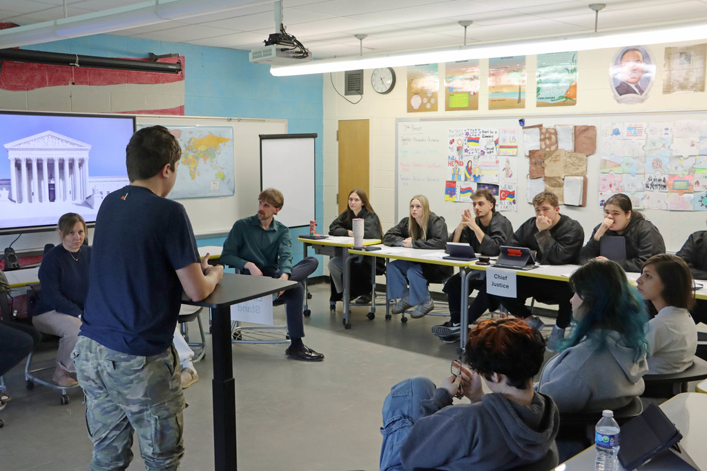 A student argues as a lawyer in front of student supreme court judges. 