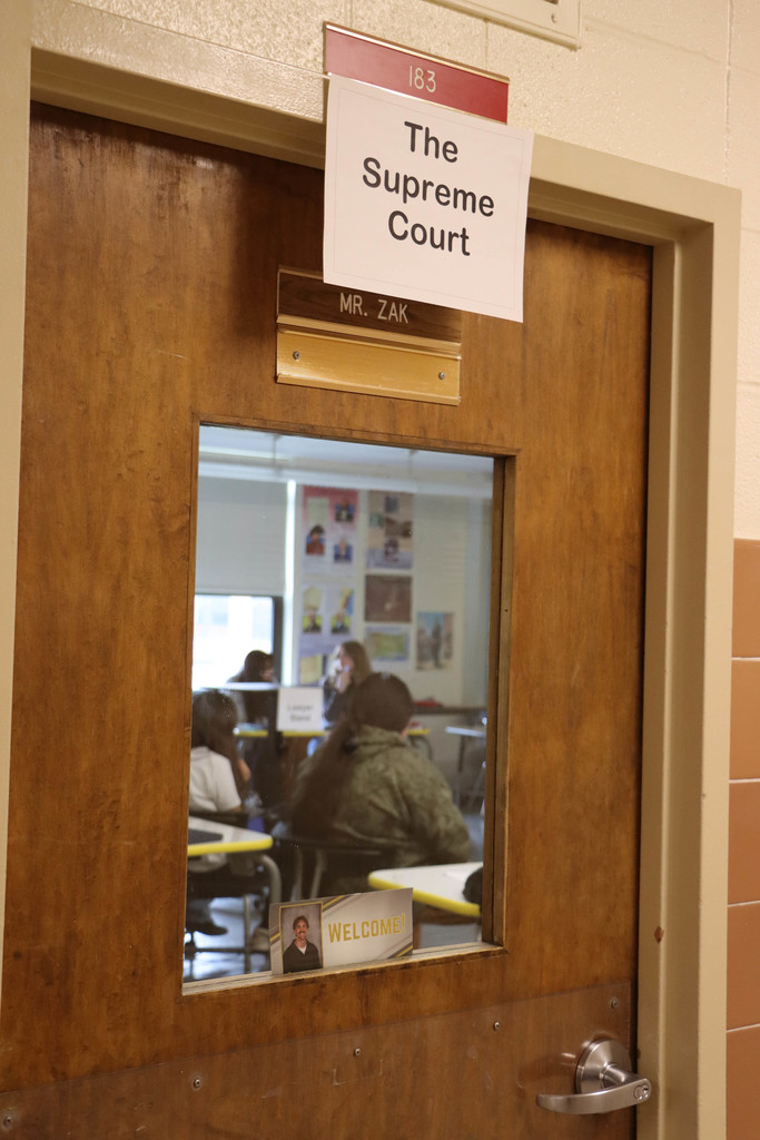 the supreme court is in session in Mr. Zak's classroom, as shown by a sign on the door. 