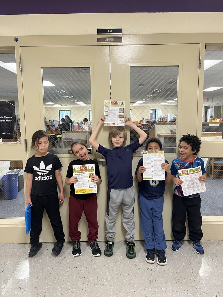 elementary students posing in front of the library