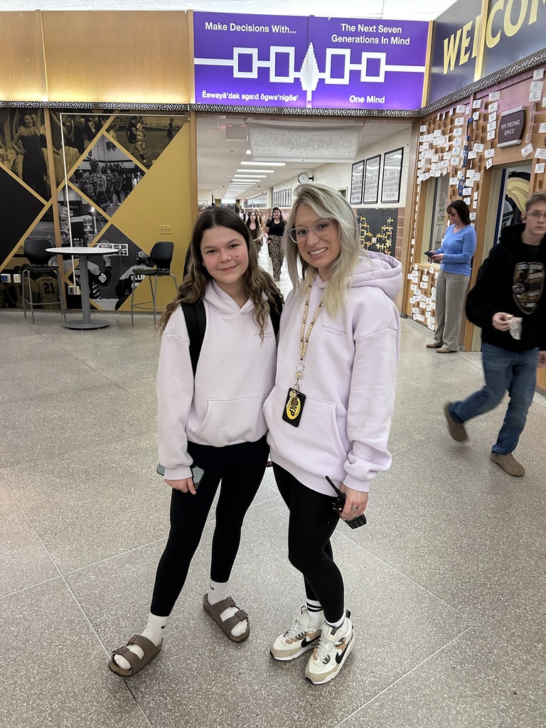 Miss Neubauer and a student twin in black leggings and purple hoodies