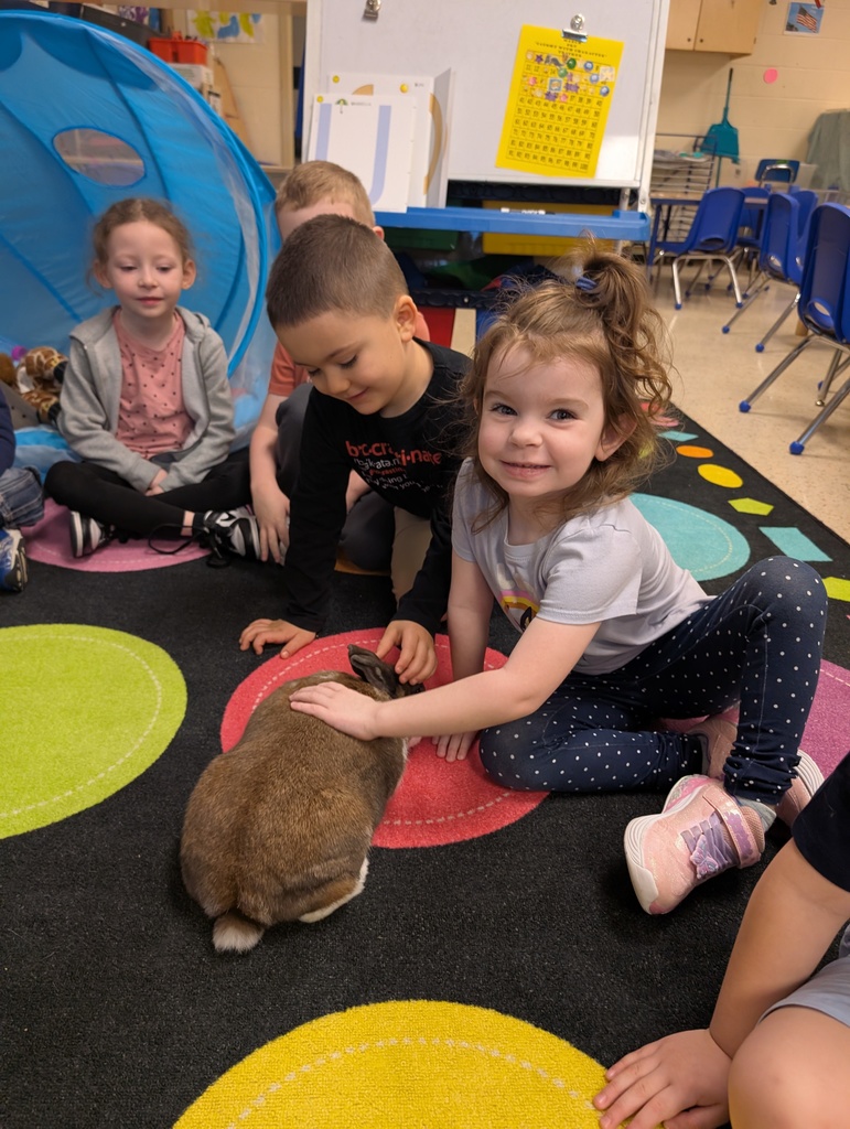 kids smiling and petting a bunny