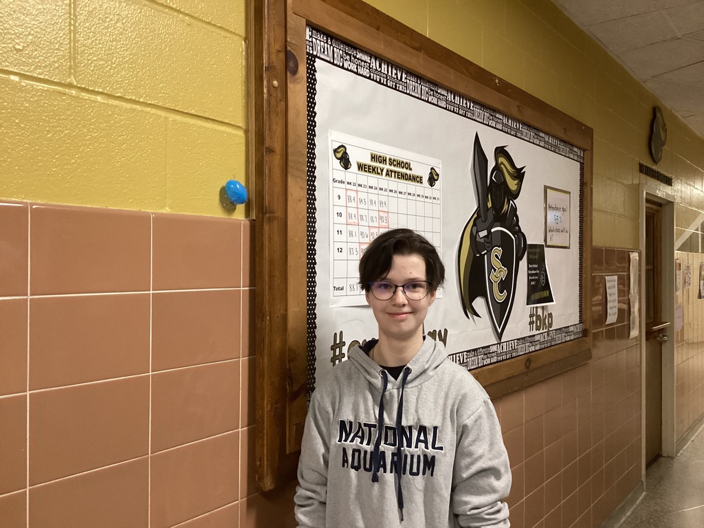 A student poses near a hidden egg