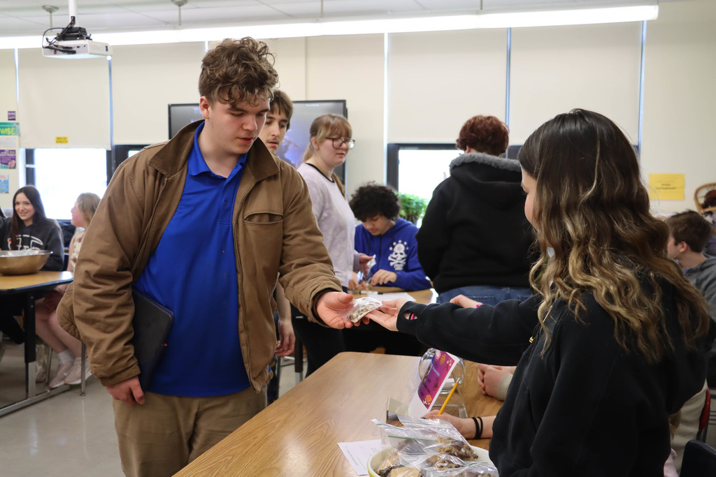 Smore's cookie team hands out a cookie. 