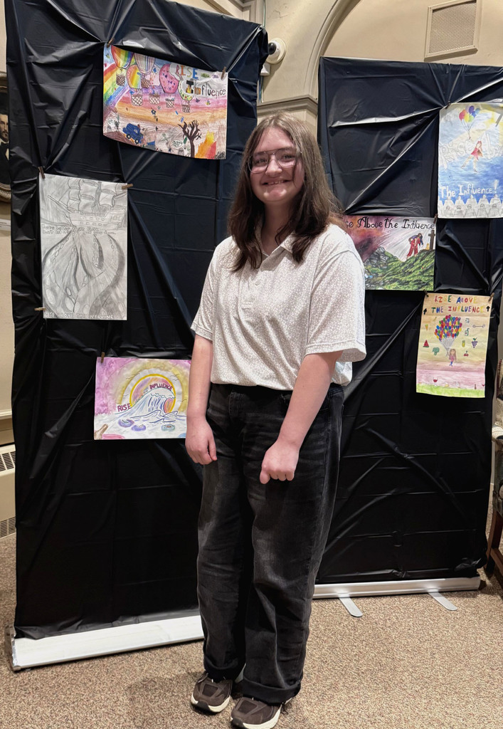 Bailee standing by wall of artwork