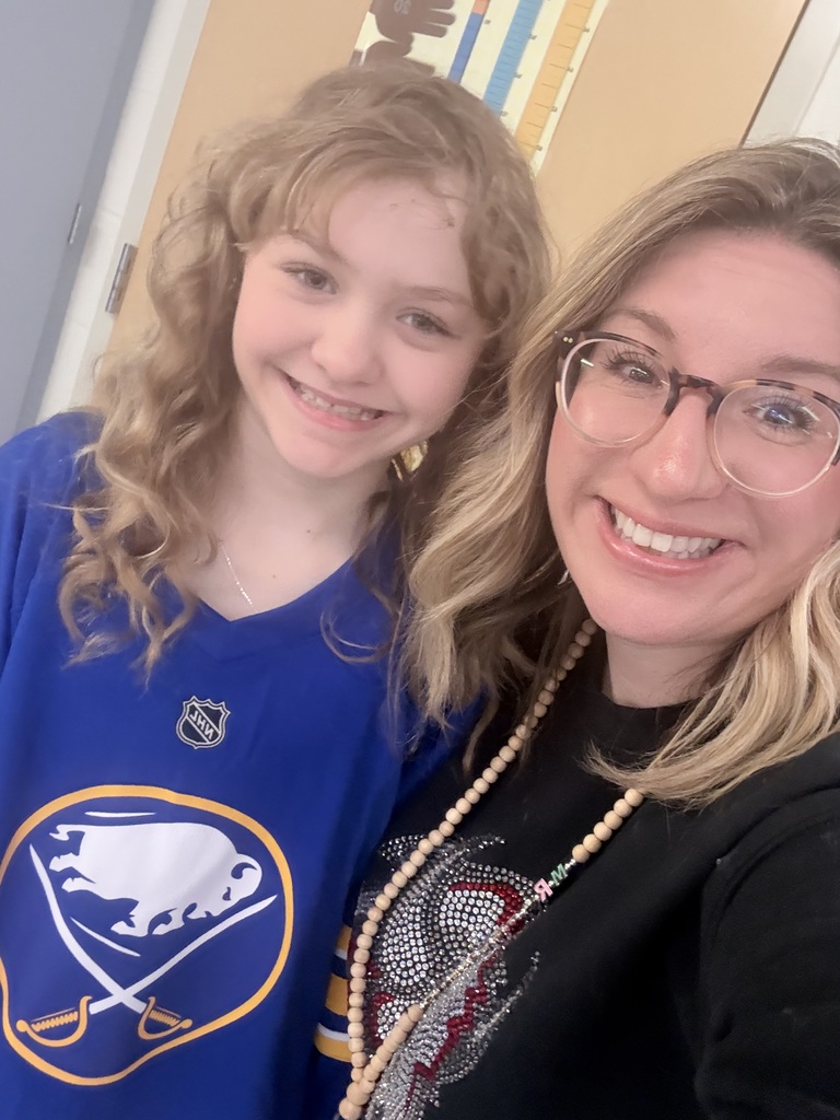 A student wears a Sabres' jersey with Mrs. Radoani.