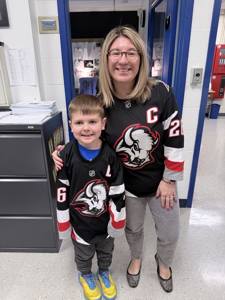 Mrs. Radoani and student in Dahlin Sabres jerseys smiling for camera
