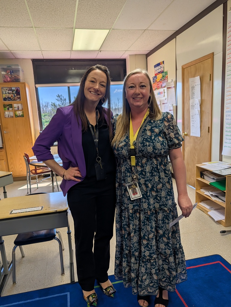 Dr. Ralston and Mrs. Weiss smile in a classroom