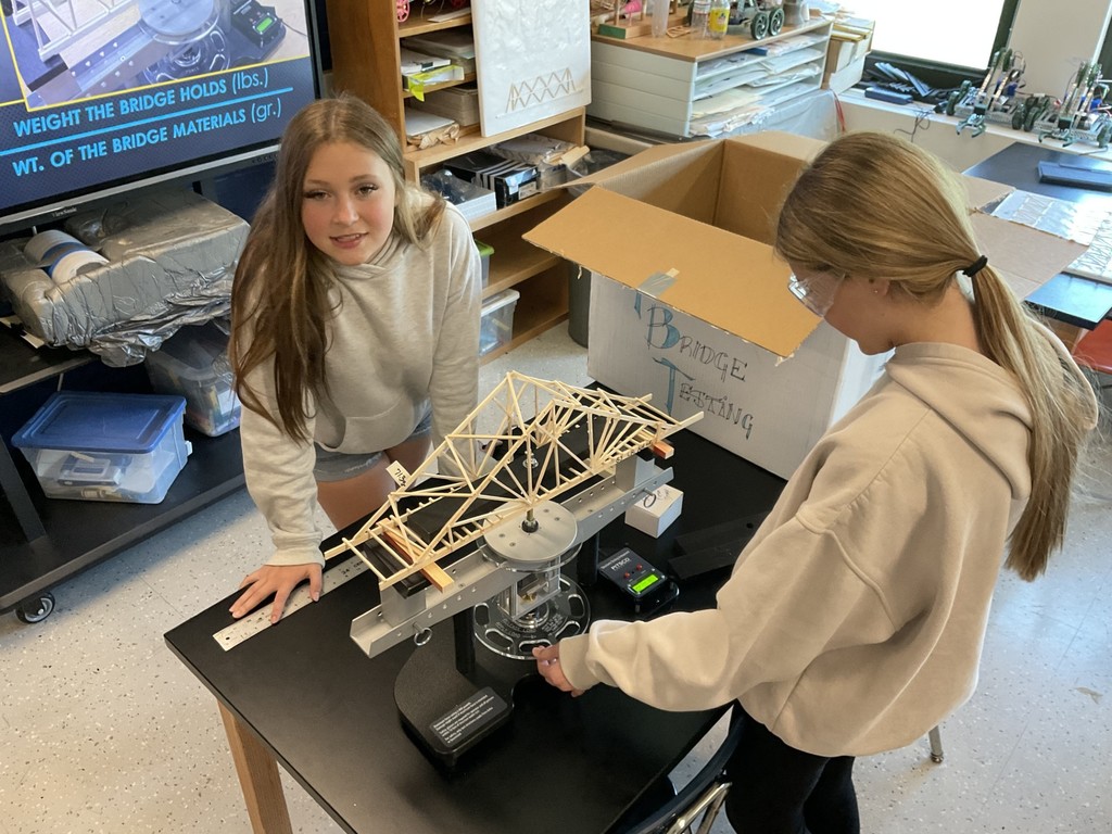 tech students build a bridge model in a classroom