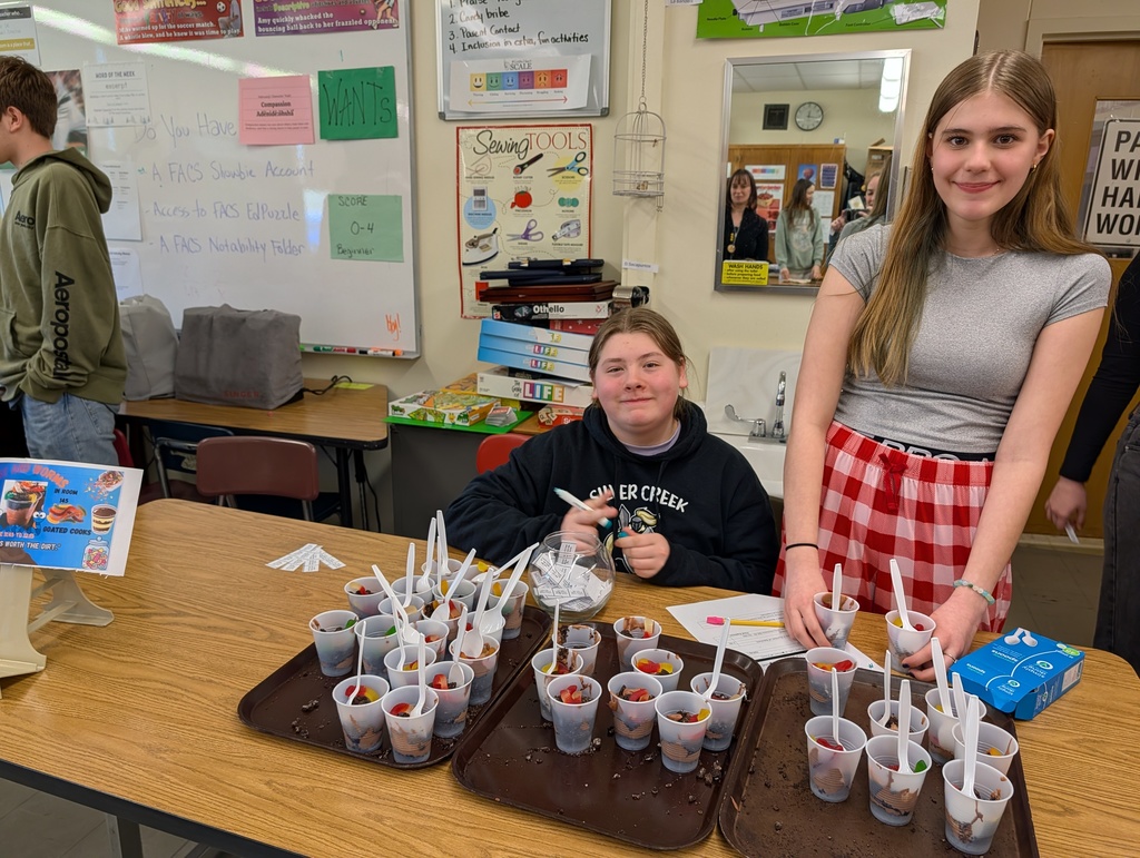 students smiling at a table with worm and dirt snack cups