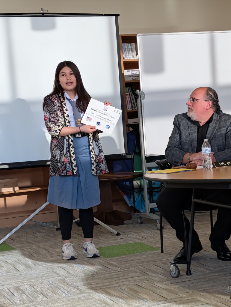 Elisabeth speaks at the meeting as Mr. Bogosian looks on