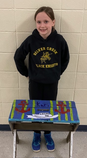 Female student posing with a nautical themed table