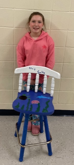 female student posing with an ocean themed chair