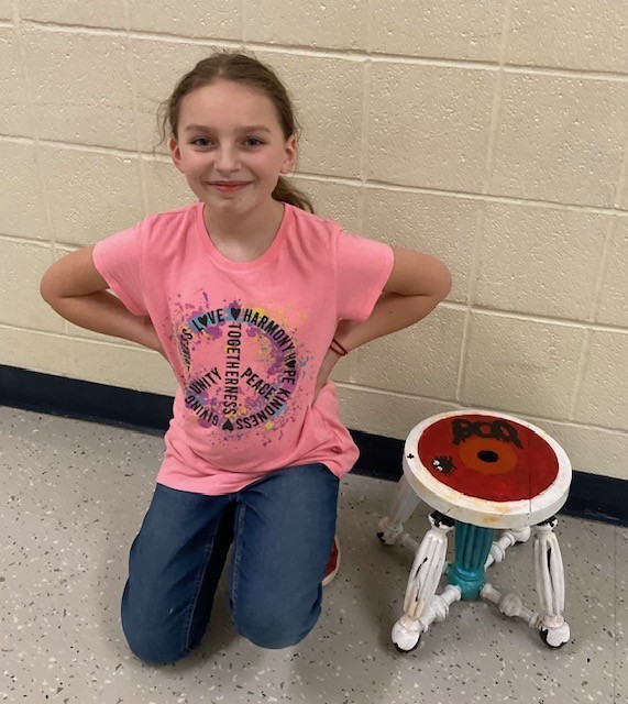 female student posing with a stool
