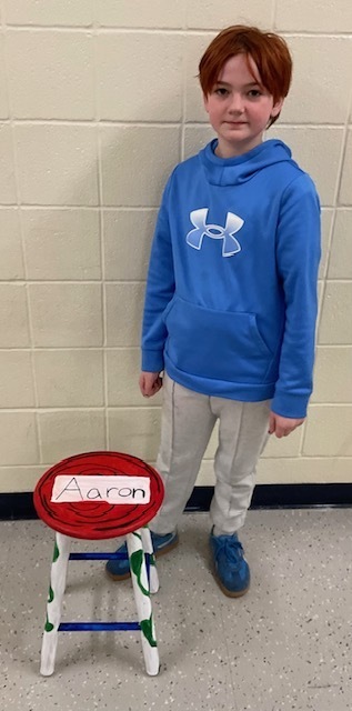 Male student posing with a stool