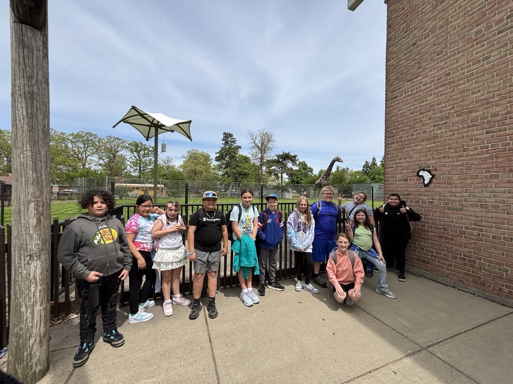 group of students smiling by giraffe yard