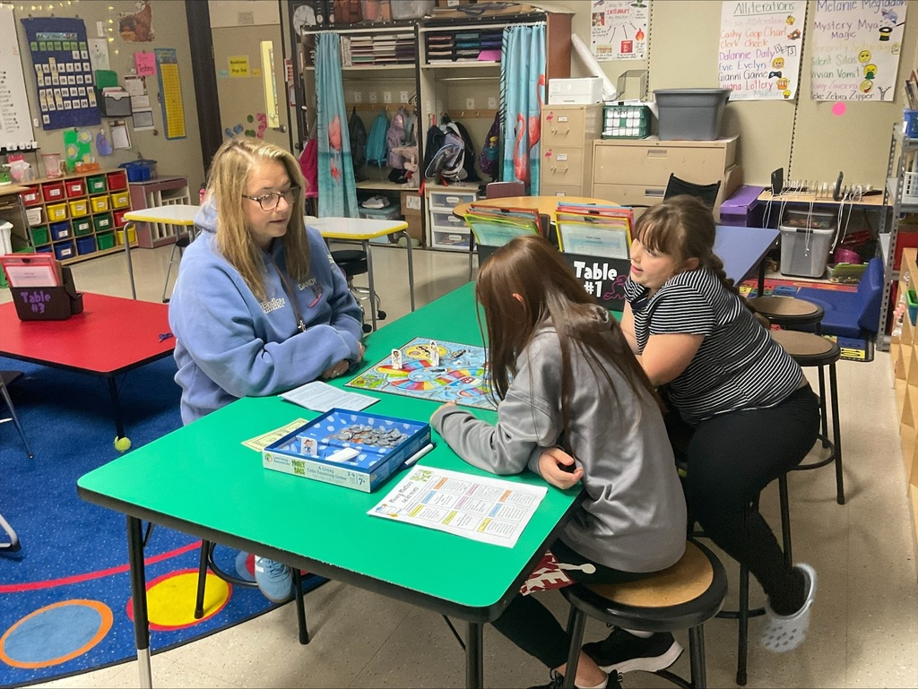 Mrs. Pagano playing a board game with students