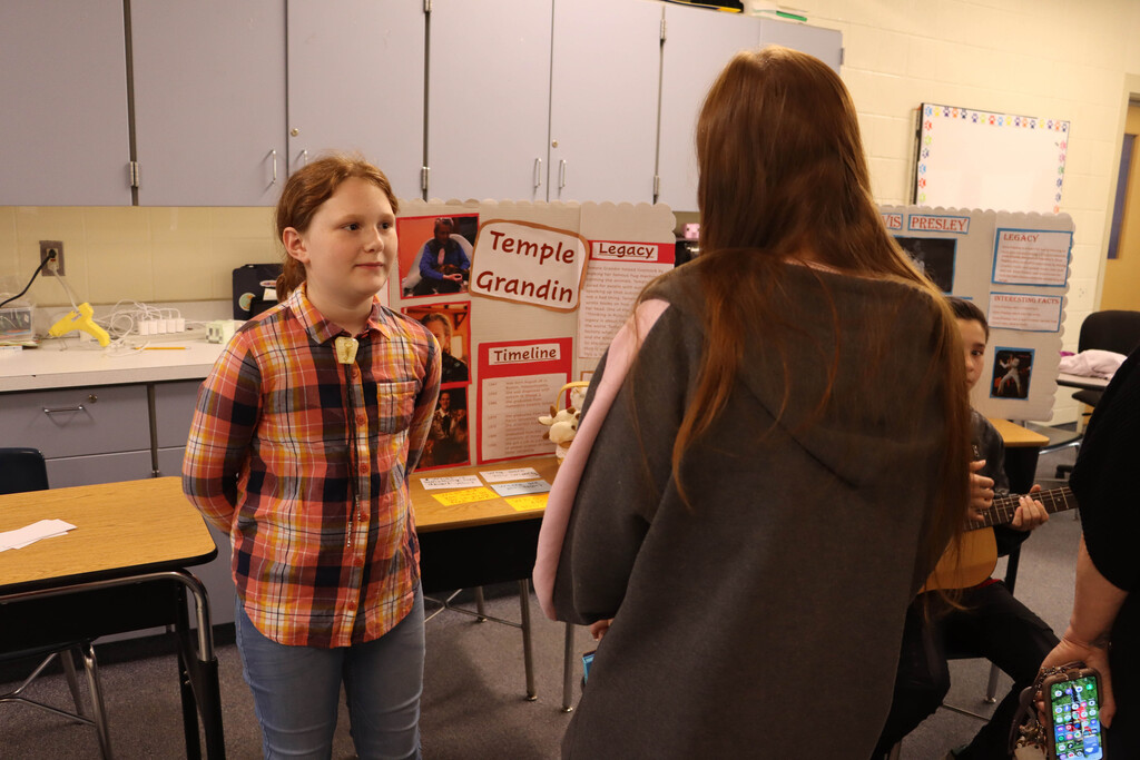 A student speaks to a visitor as Temple Grandin. 