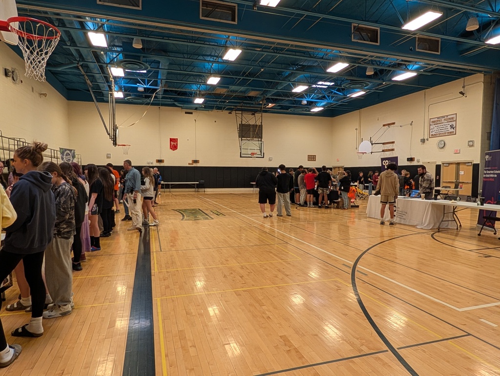 Students in gym at career day tables