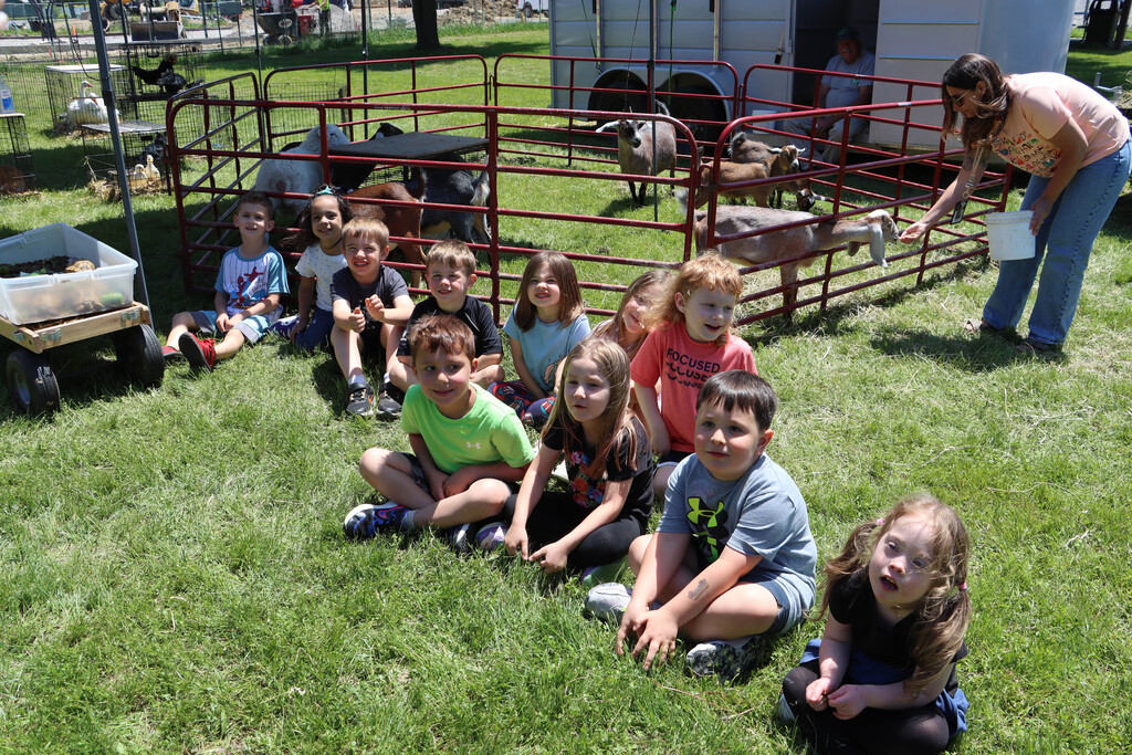 students pose for a photo with the goats. 