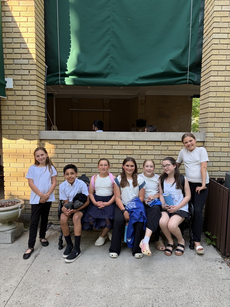 students smiling seated on a bench