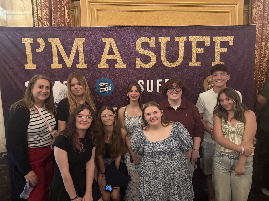 Club members in front of an "I'm a SUFF" sign. 