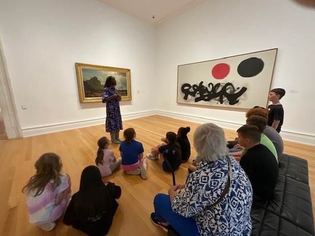 Students listen to a Docent. 