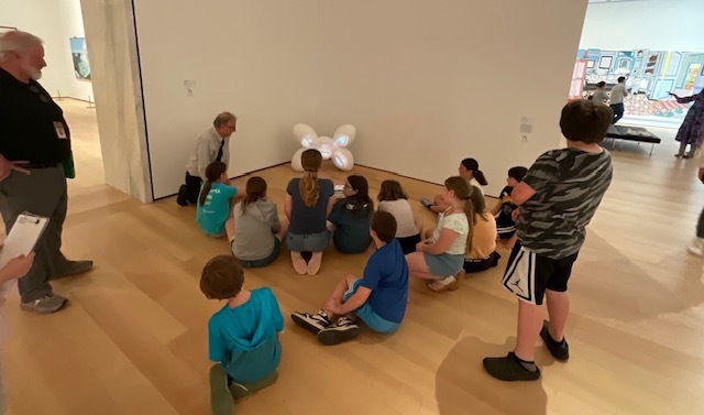 Students with a light work on the ground. 