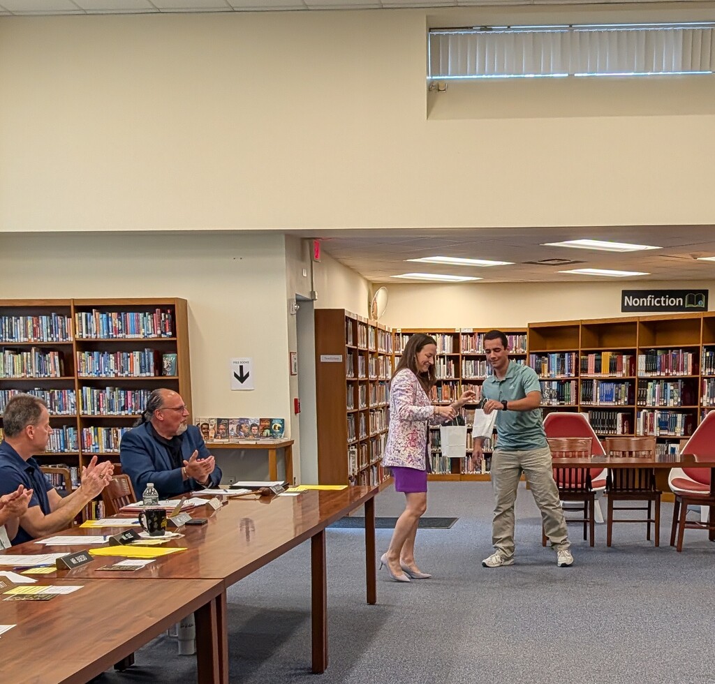 Dr. Ralston handing gift bag to Nate Cross