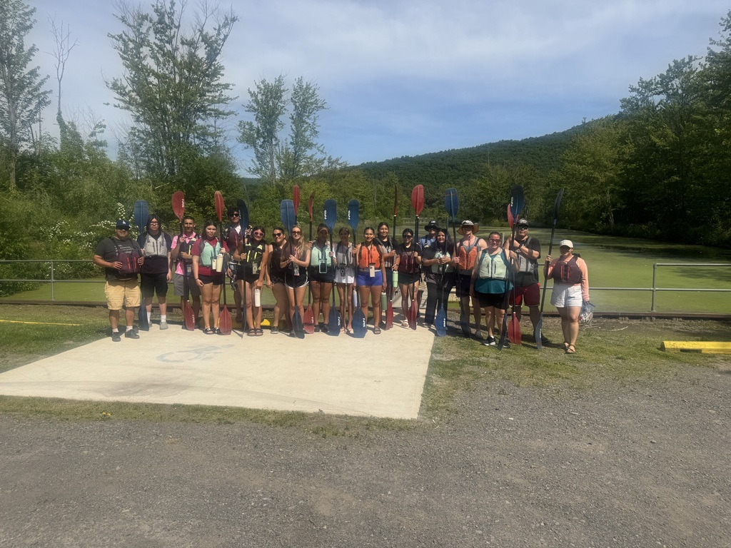 Group Photo with students holding oars. 