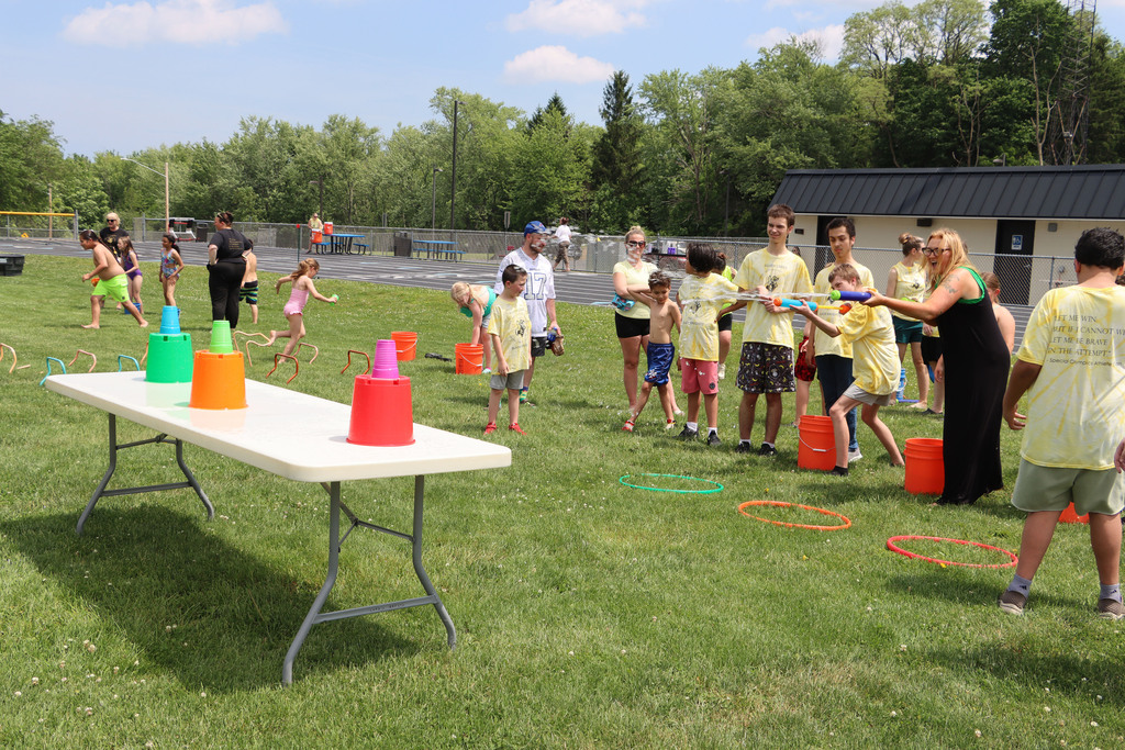 Students try to knock over cups with water  squirters. 