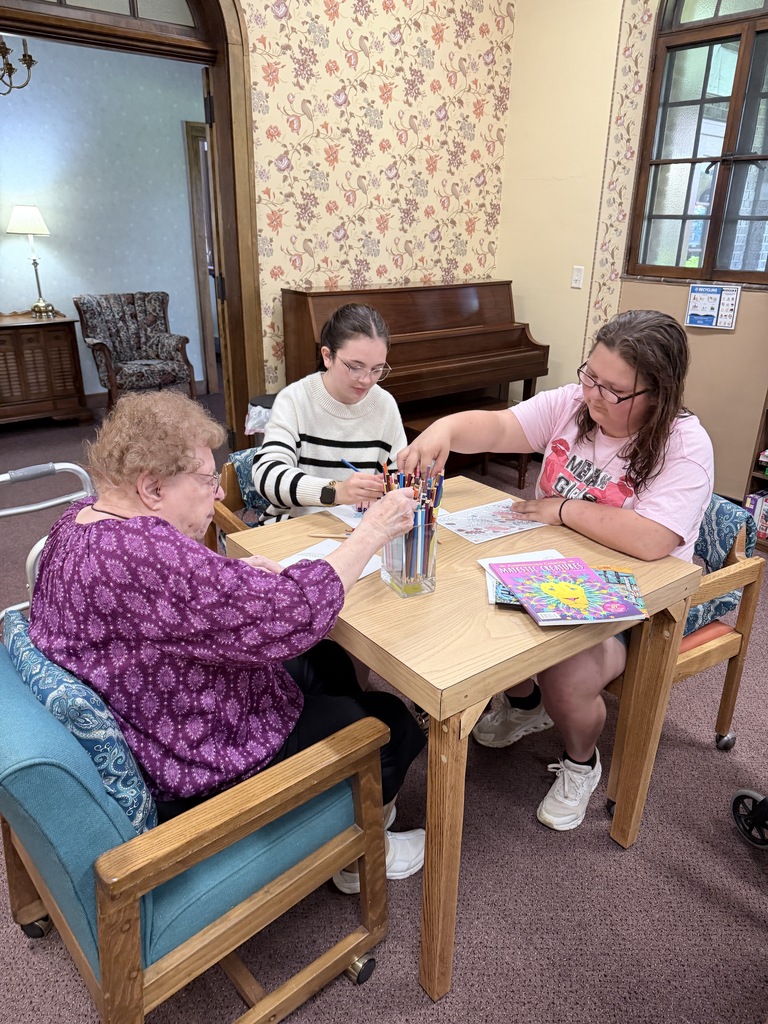 students and senior residents pick colored pencils from a jar