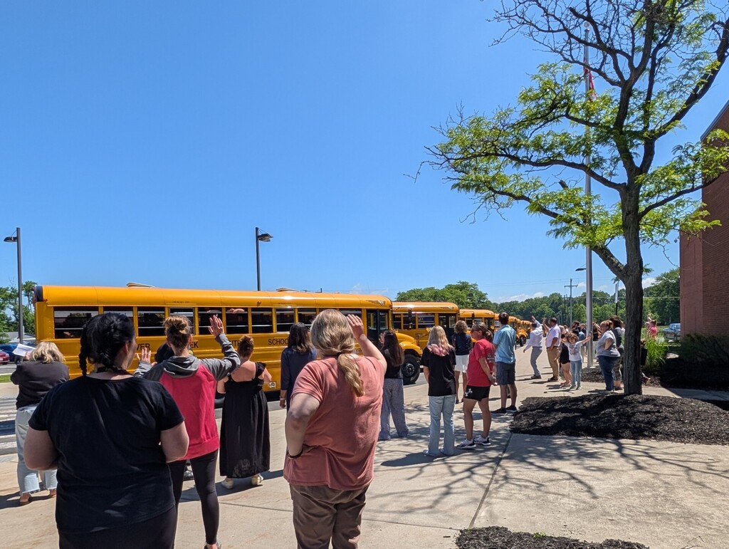 Staff waving to buses