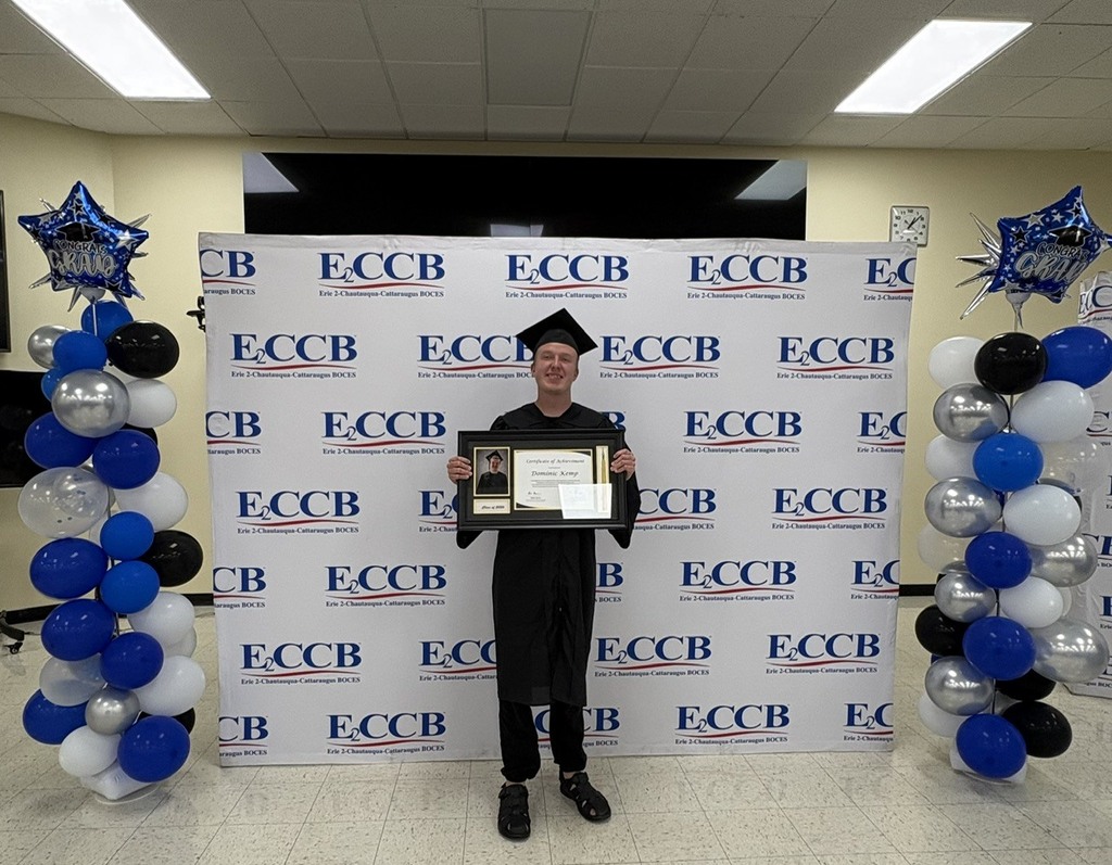 a graduate holds a plaque. 