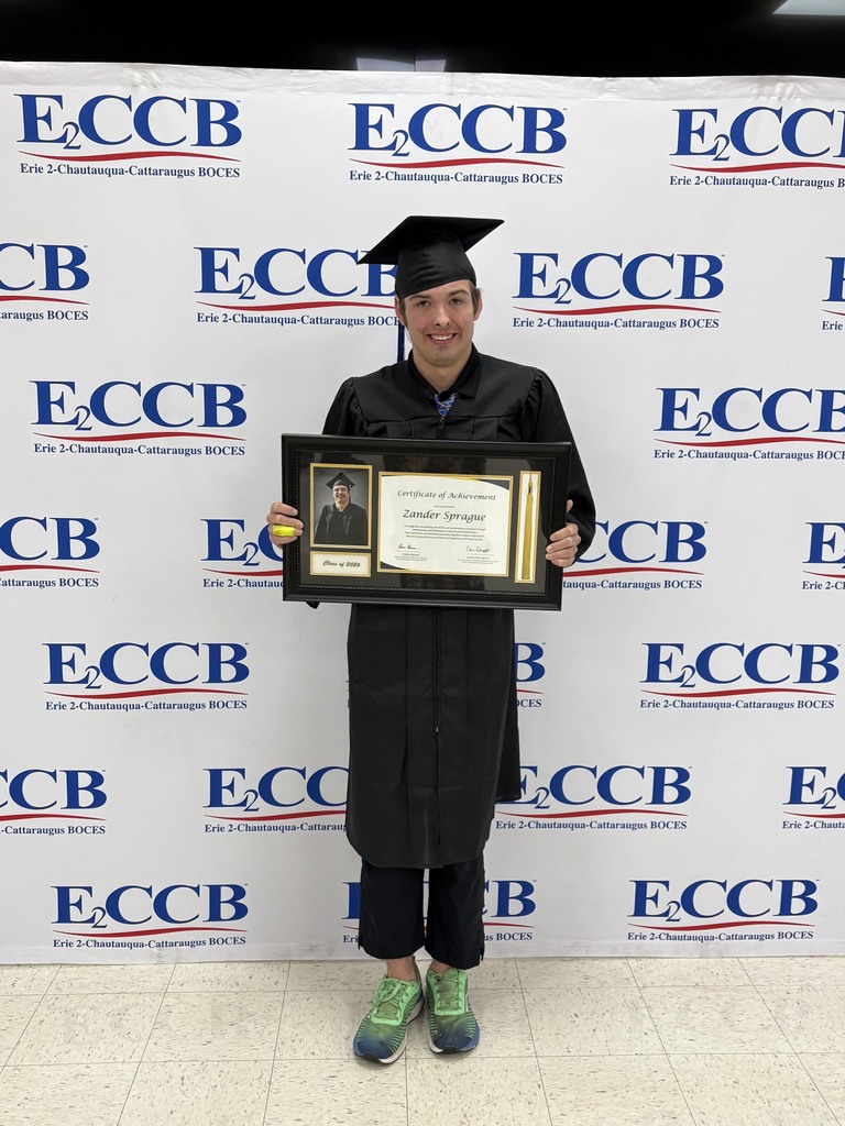 a graduate holds a plaque. 