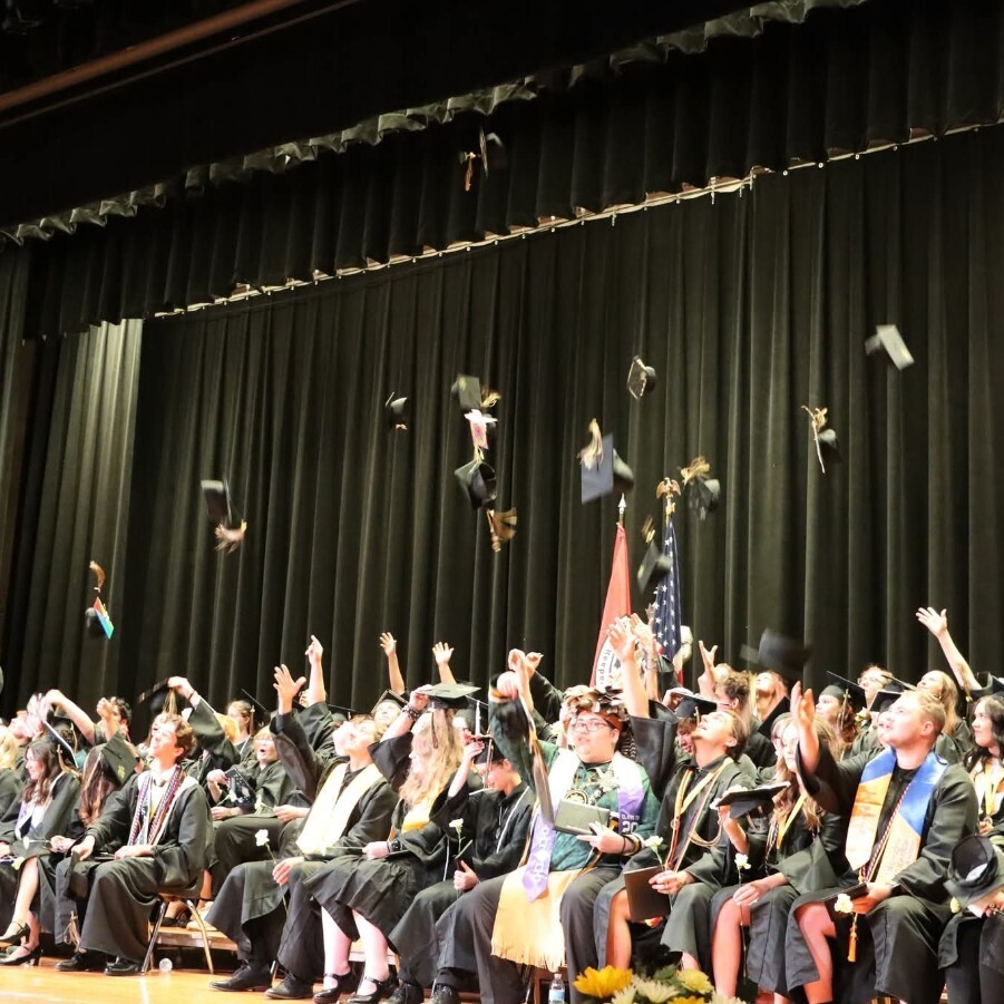 graduates toss caps in air