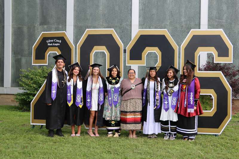 Students and teacher in front of the 2026 sign.