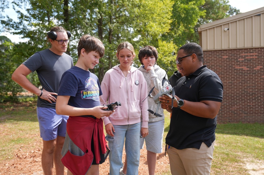 Unmanned Aircraft Systems instructor showing a drone to a group of students.