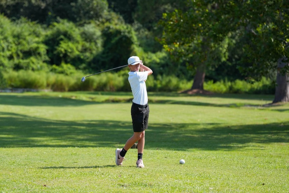 Mendenhall High School Golfer taking a swing at a golf ball.