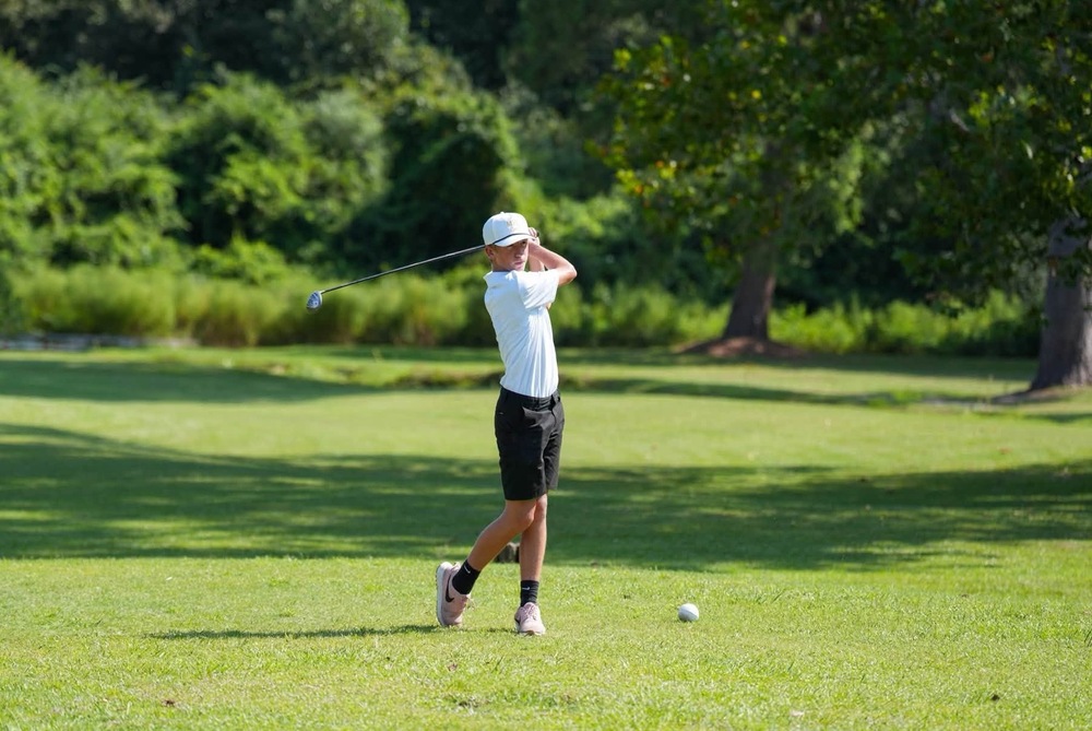 Mendenhall High School Golfer taking a swing at a golf ball.