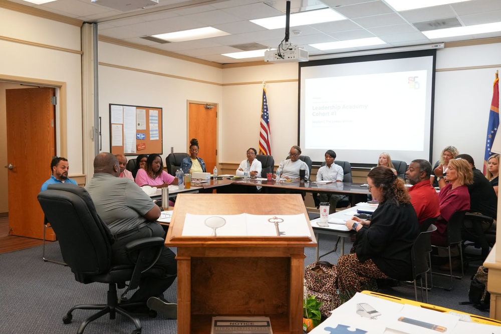 District Leaders gather around a table during first Leadership Academy session.