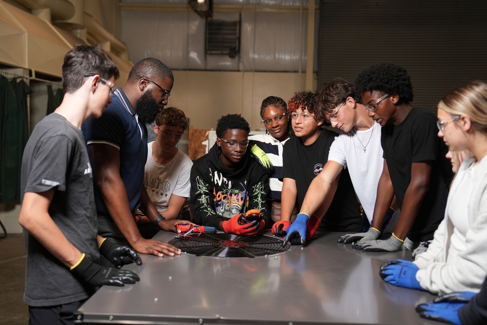 HVACR students and instructor examining an air conditioning unit