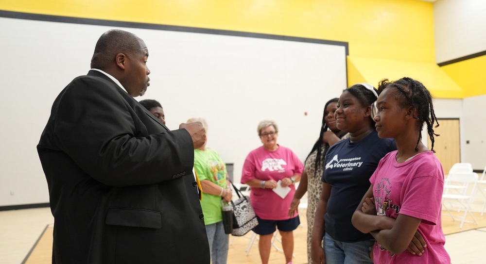 Dr. Sanders is talking to a group of students and staff members at the Meet the Superintendent event at Simpson Central