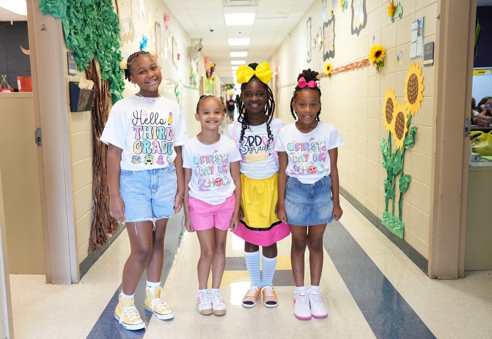 Four elementary girls pose for a picture in the hallway of Mendenhall Elementary on the first day of school.