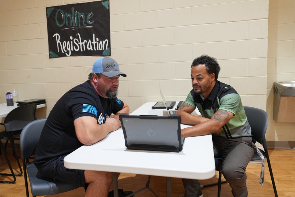 Two men looking at a laptop.