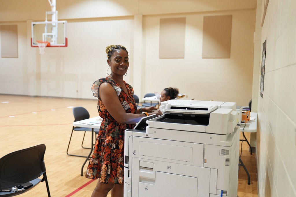 Magee Elementary Principal, Cindy Allbritton, smiling while using a printer. 