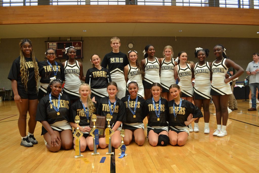 Mendenhall High School Cheerleaders pose for a photo at cheer camp with awards.