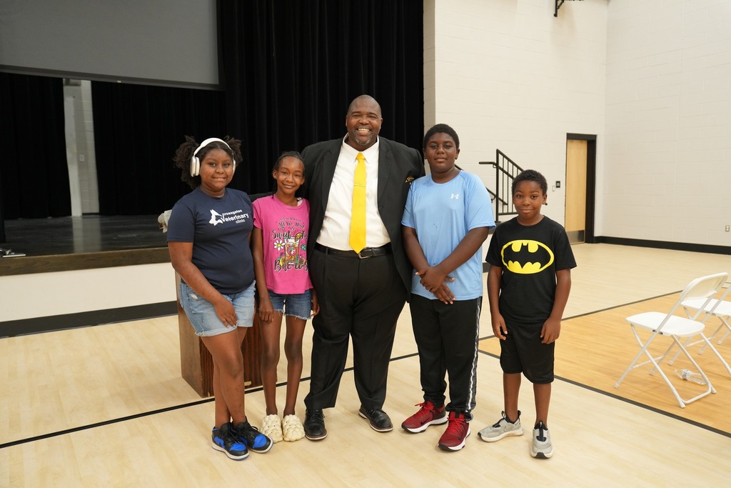 Dr. Robert Sanders poses for a photo with Simpson Central students.
