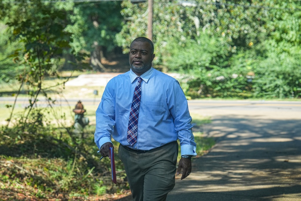 Magee High School Principal is walking in the street to do a home visit. 