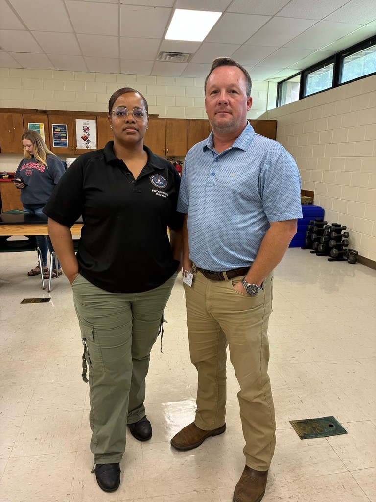 Law and Public Safety instructor poses for a photo with FBI representative.