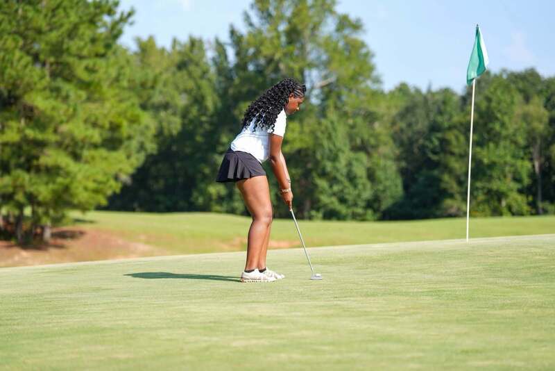 Mendenhall High School Golfer taking a swing at a golf ball.